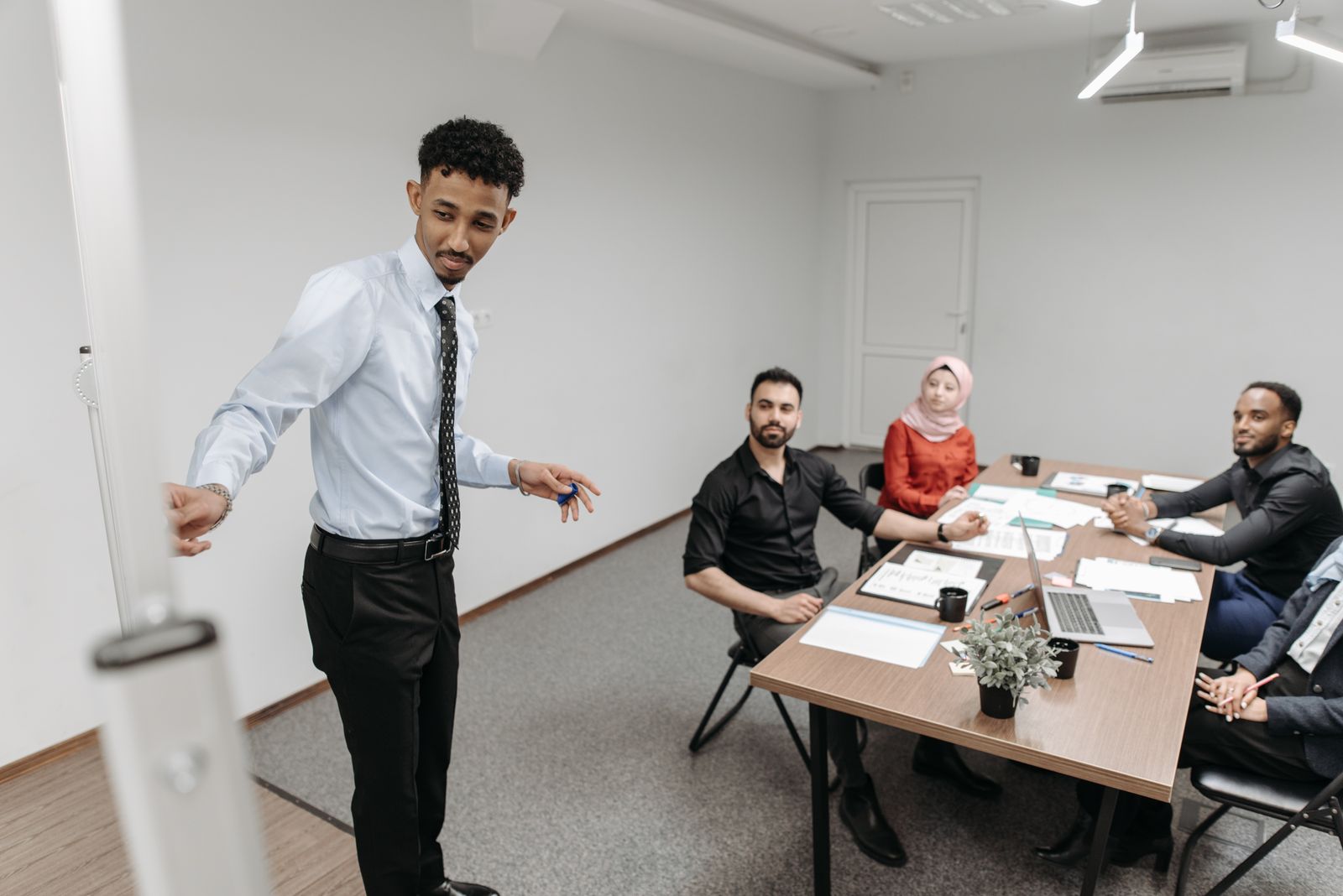 Presenter briefing a team of managers around a meeting table on Martyn's Law duties